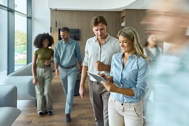 istock Happy business colleagues using touchpad among people in blurred motion. 2240225475