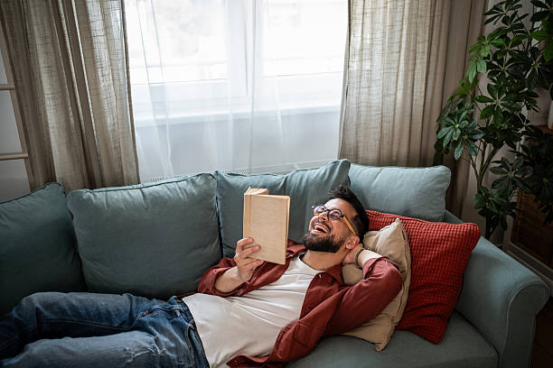 istock Man relaxing at home enjoying a good book 2240226418