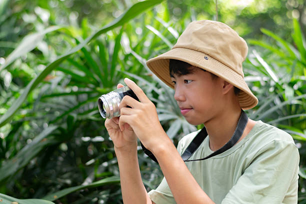 istock Asian teenaged boy with camera holding. 2240235867