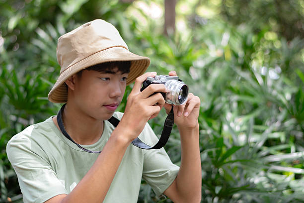 istock Asian teenaged boy with camera holding. 2240235868