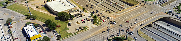 istock Panorama aerial highway interchange overpass structure, flat-roof restaurant pads, fast food signage, retail stores parking lots, traffic lights, feeder roads, suburban homes North Richland Hills 2240236971