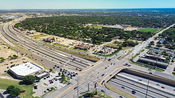 istock Curved NE Loop 820 highway interchange in North Richland Hills, Texas, intersecting restaurant pads, suburban homes, and school district stadium with green fields and layered zoning transitions 2240236992