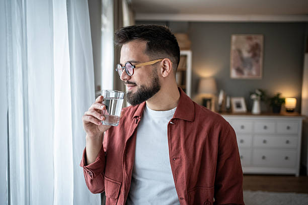 istock Man drinking fresh water at home for healthy lifestyle 2240238164