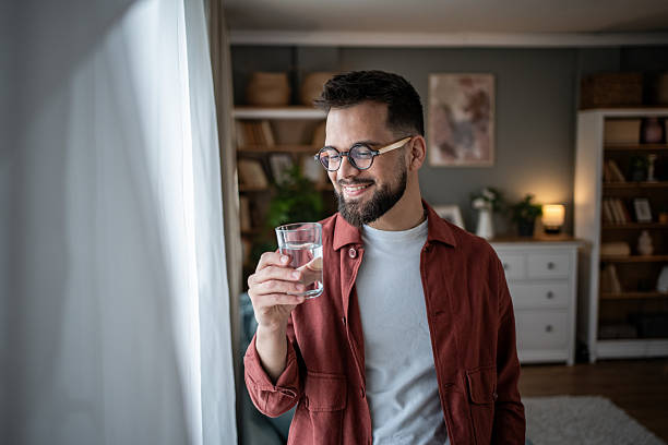 istock Young man smiling and drinking water for health hydration 2240238202