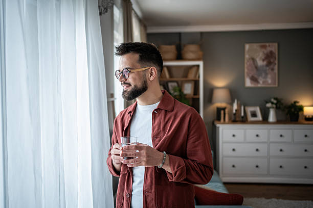 istock Young man enjoying calm morning at home drinking water 2240238252