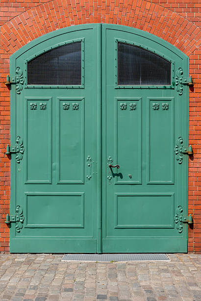 istock Green wooden gate on a brick wall 2240238397