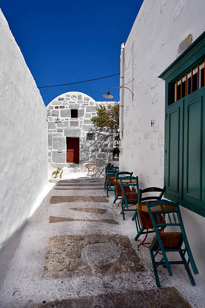 Astypalea, Greece -  Chora, the stunning white town and a typical narrow alley with seatings in the old town