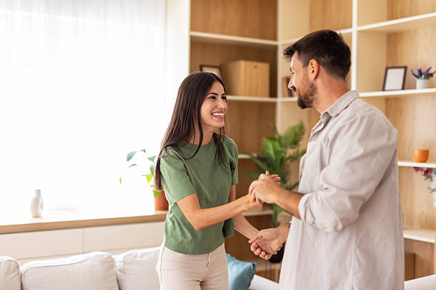istock Young couple smiling, dancing romantically at home, celebrating love 2240245363