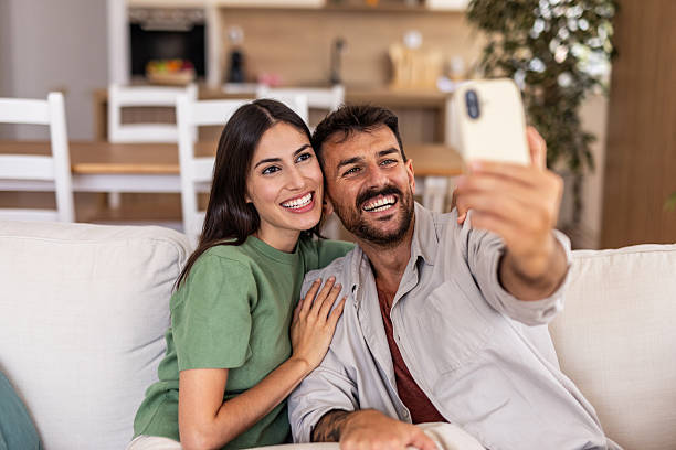 istock Happy couple taking selfie on couch at home 2240245800