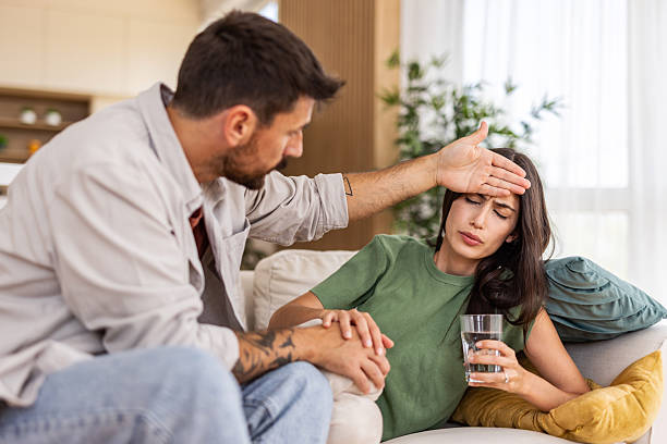 istock Concerned man checking for fever on his sick girlfriend at home 2240245874