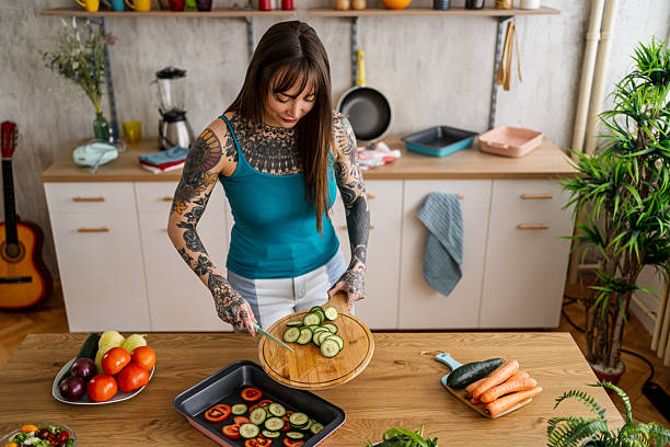 istock Tattooed woman preparing healthy dinner with fresh vegetables 2240246293