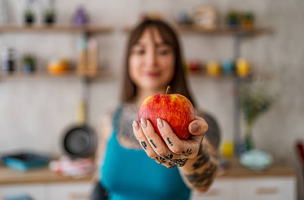 Woman offering fresh apple for healthy diet
