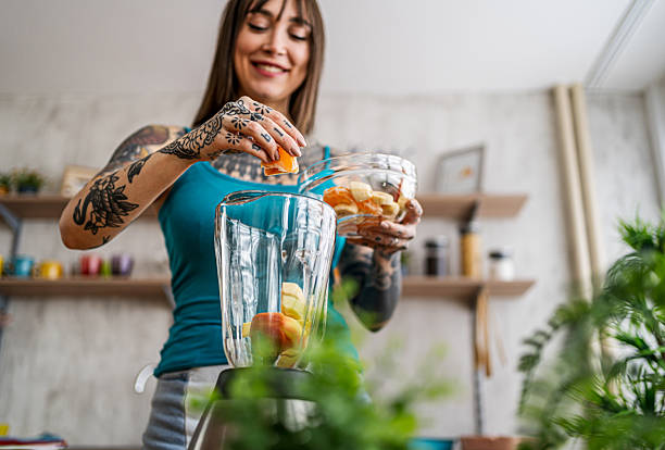 istock Woman preparing healthy fruit smoothie in kitchen 2240246517