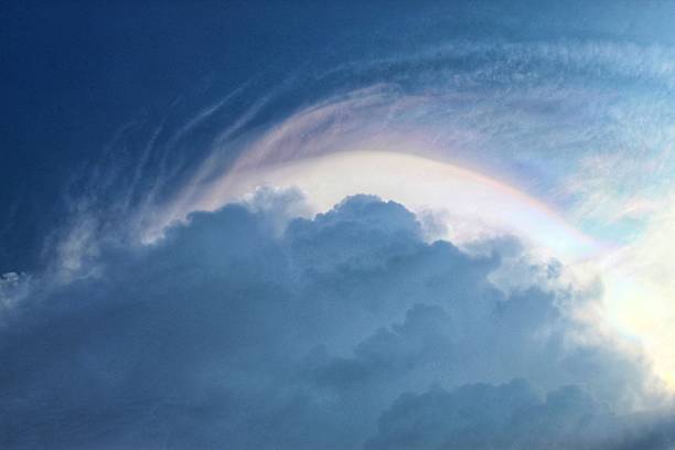istock a sky with dramatic blue and white cloud formations, accompanied by a faint rainbow of light in the form of an arch above the clouds 2240248215