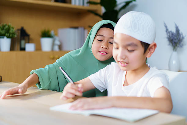 istock Muslim siblings study together, doing homework and reading in the study room. 2240249120