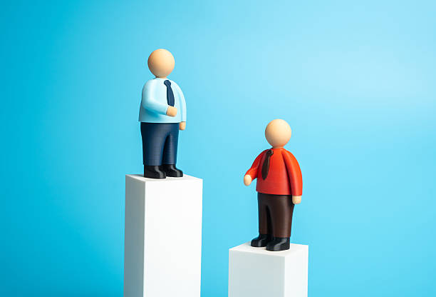 istock Two office workers on pillars of different heights. They have different incomes 2240249382