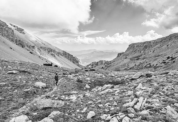 National park of Majella, Italy - 25 August 2024 - Mountain summits in the Majella range, central Italy, Abruzzo region, with characteristic landscape of rocky expanses between valleys and plateaus. Here in particular Cima dell'Altare and Altare dello Stincone with girl hiker
