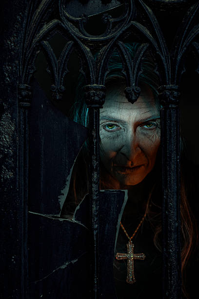 Mysterious older woman with glowing eyes stares through broken gothic bars, wearing a gold cross, evoking dark supernatural vibes.