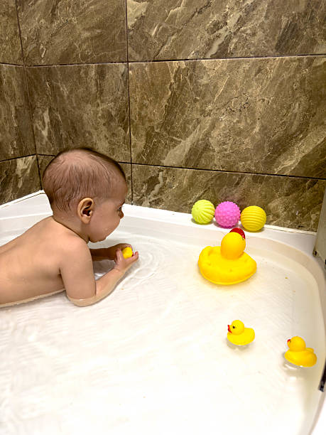 istock Baby Playing with Rubber Ducks in Bathtub 2240259058