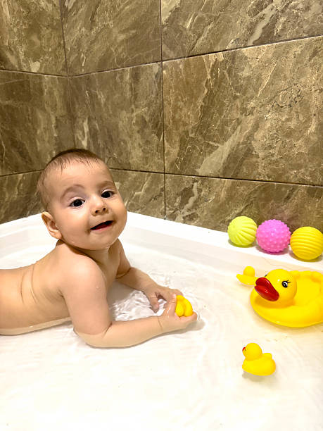 istock Baby Playing with Rubber Ducks in Bathtub 2240259059
