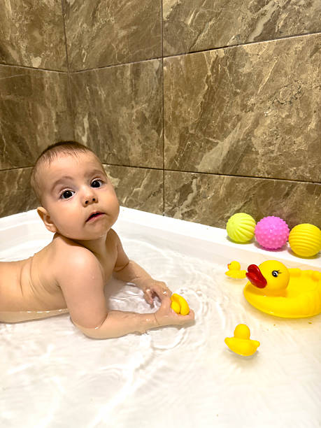 istock Baby Playing with Rubber Ducks in Bathtub 2240259822