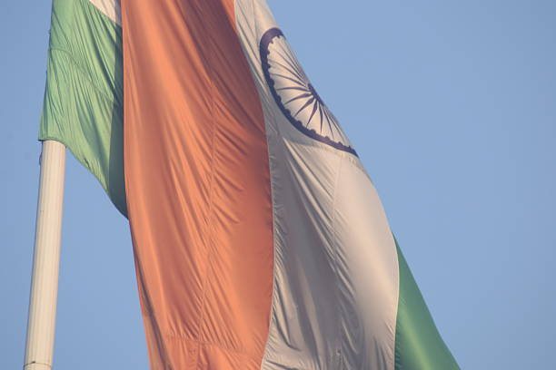 istock India flag flying high at Connaught Place with pride with plain white background, India flag fluttering, Indian Flag on Independence Day and Republic Day of India, tilt up shot, Har Ghar Tiranga 2240259989