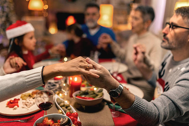 istock Family praying together before Christmas dinner at home 2240260335