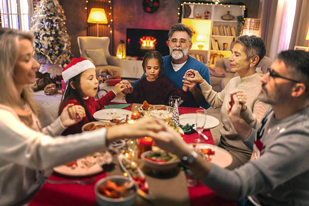 istock Family praying together before Christmas dinner at home 2240260356