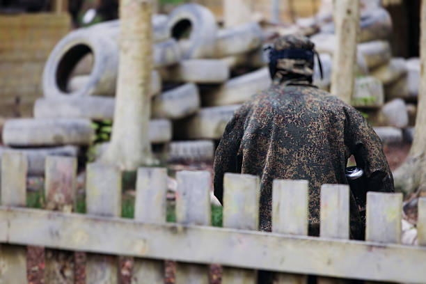 Dynamic paintball battle. Player jumping and aim