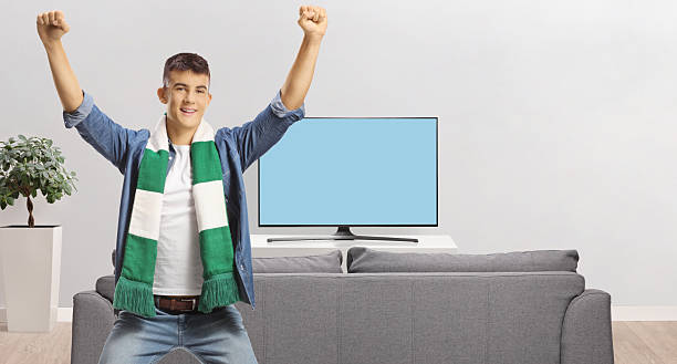 istock Young man with a green and white scarf cheering 2240262002