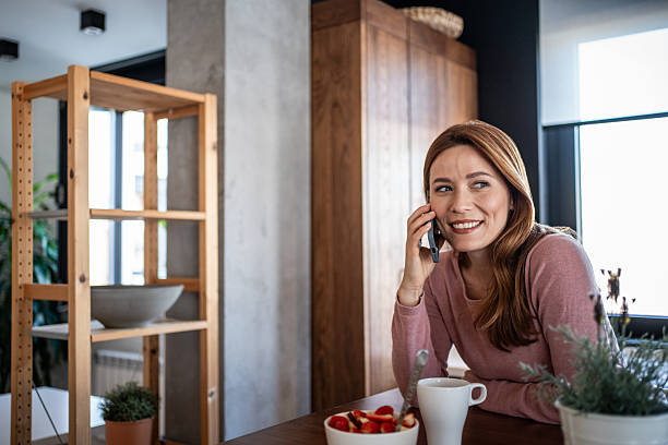 istock Woman talking on phone smiling during healthy breakfast 2240263149