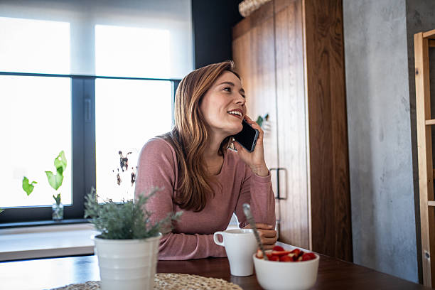 istock Woman talking on smartphone enjoying breakfast in kitchen 2240263153
