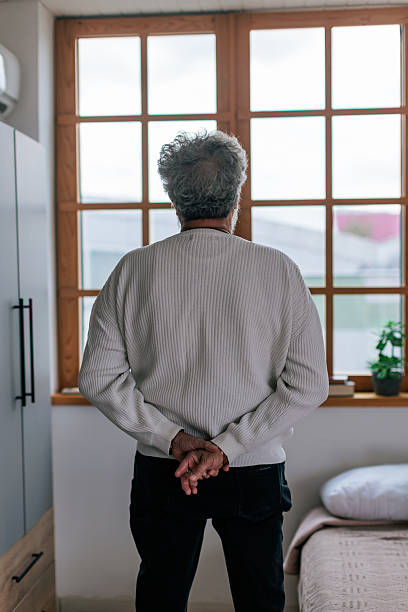 istock Mature Man Living with Obesity Looking Out the Window 2240263321