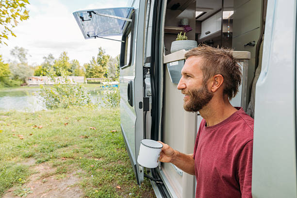istock Man Relaxing Outside Camper Van with Coffee 2240264505