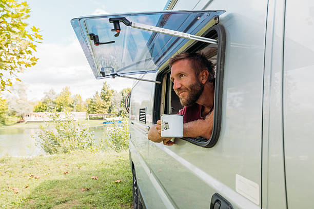 istock Man Enjoying Coffee from Camper Van Window 2240264630