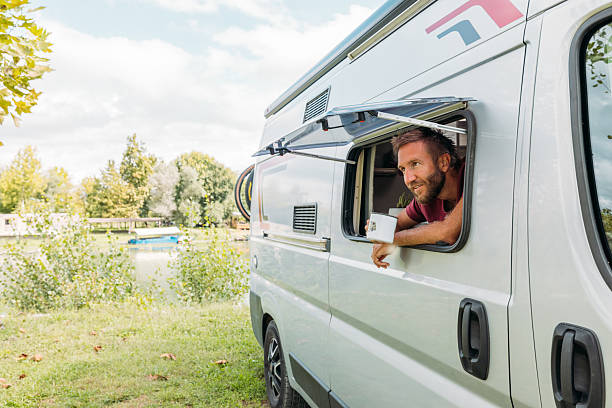 istock Man Leaning Out Camper Van Window Holding a Mug 2240264687