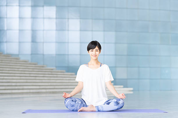 istock Young woman practicing yoga in a studio 2240267881