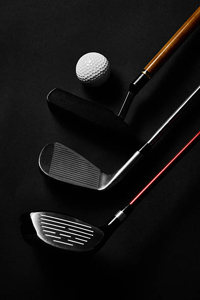 istock Golf ball with putter, wedge and driver arranged on black background 2240270622