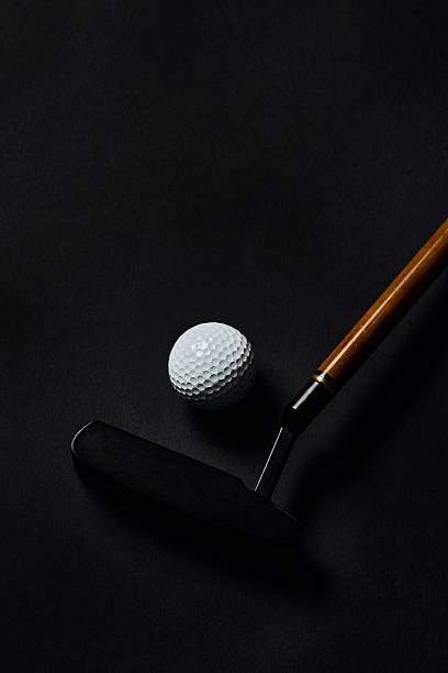istock Golf ball and putter with wooden shaft on dark textured surface 2240270624