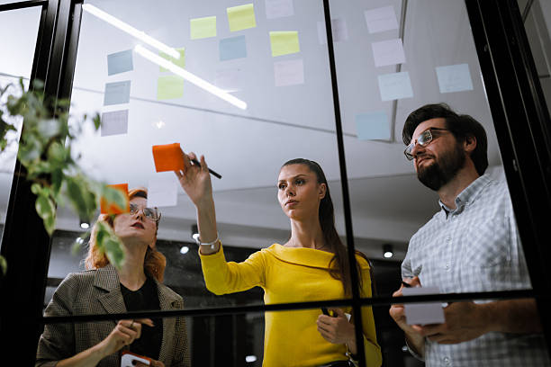 istock Creative brainstorming session in an office environment with team members collaborating on sticky notes 2240272592