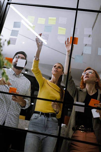 istock Collaborative brainstorming session in an office with diverse individuals organizing ideas on sticky notes 2240272597