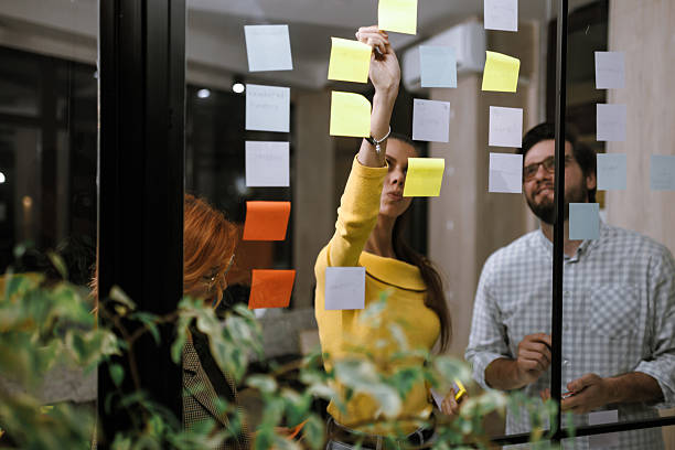istock Team collaboration during a brainstorming session with sticky notes in a modern office space in the evening 2240272639