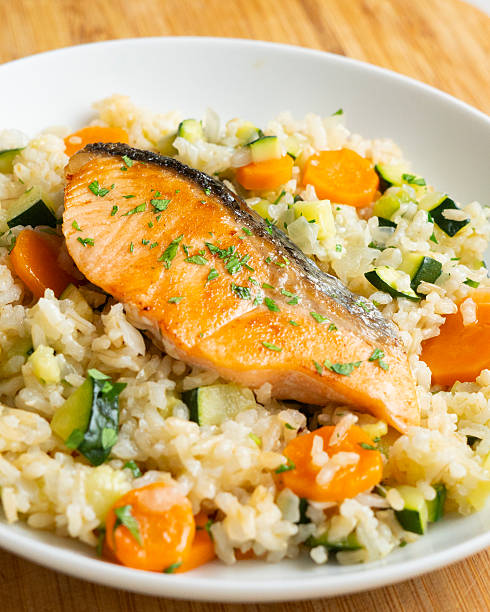 istock Rice paella with vegetables and salmon. Step-by-step recipe to learn how to cook. 2240273108