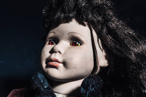 istock Old dirty porcelain doll with a broken head and scary red eyes 2240273381