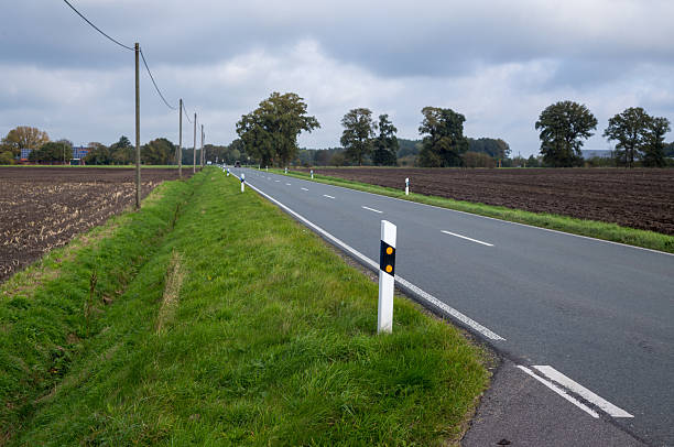 istock Countryside driving on long rural asphalt road 2240277435