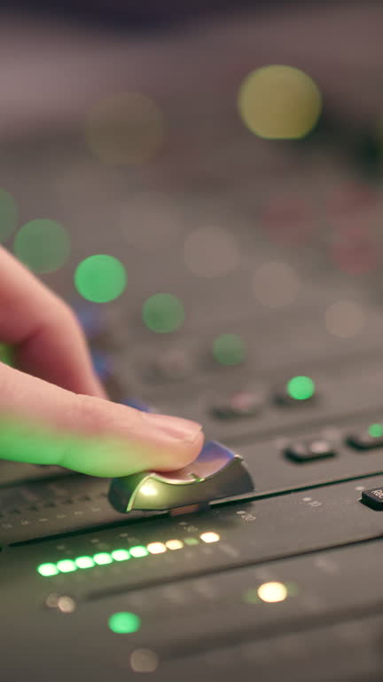 Hand, sound engineer and music in studio with console, lights and computer for mixing production. Technician, person and control editing in audio recording with faders, bokeh and tech for creativity