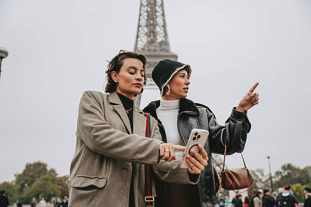 istock Two Friends Looking for a Place on Their Phone in Paris 2240283314