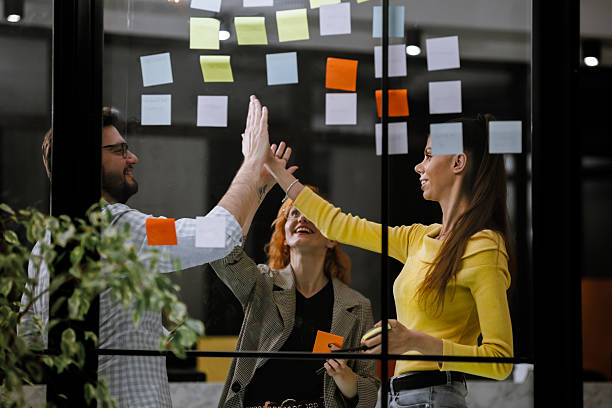 istock Team brainstorming session at modern office with sticky notes during daytime 2240283692