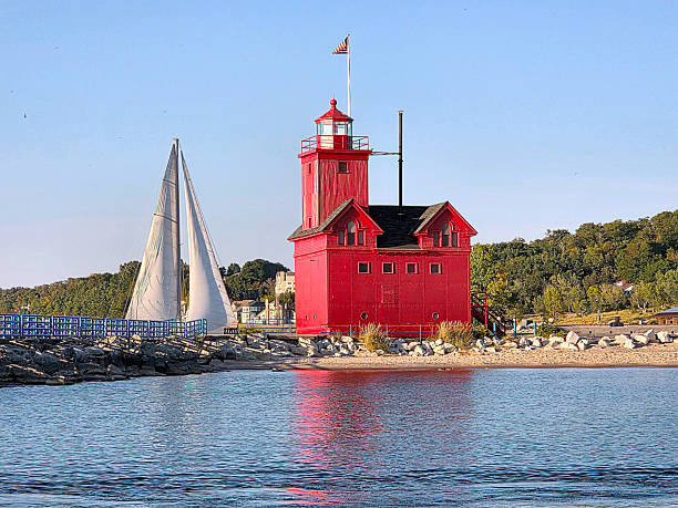 istock Michigan Big Red Lighthouse With a Sailboat 2240284750