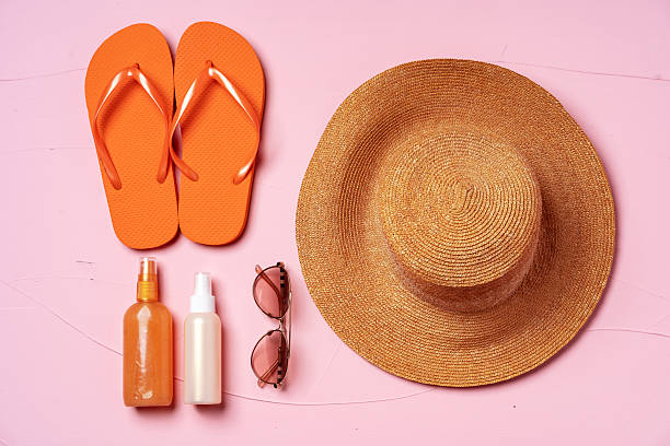 istock Suntan oil spray bottles and straw hat on pink background 2240286552
